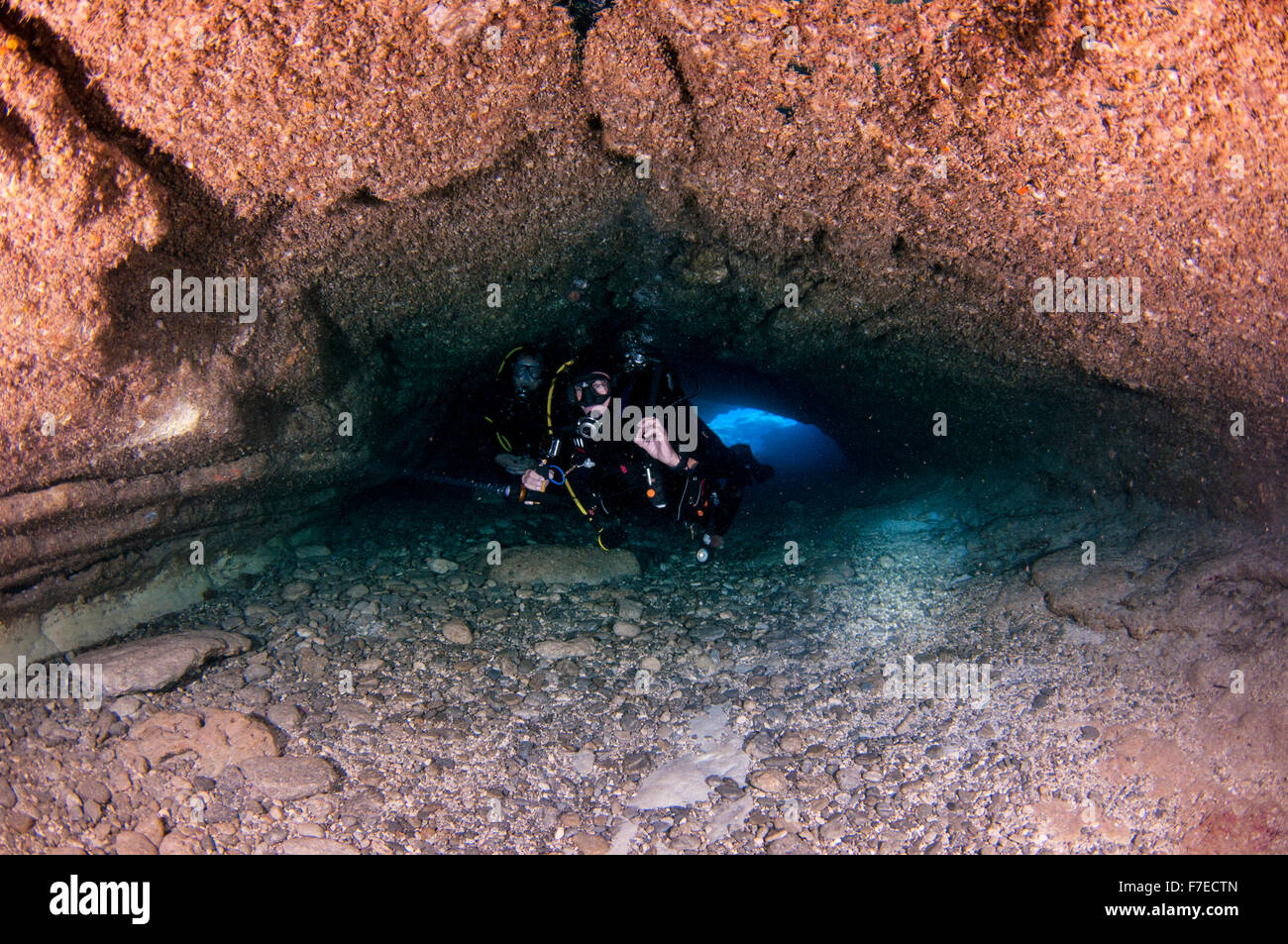 Divers explore natural caves and rocks in the Mediterranean sea off the coast of Larnaca, Cyprus, Stock Photo
