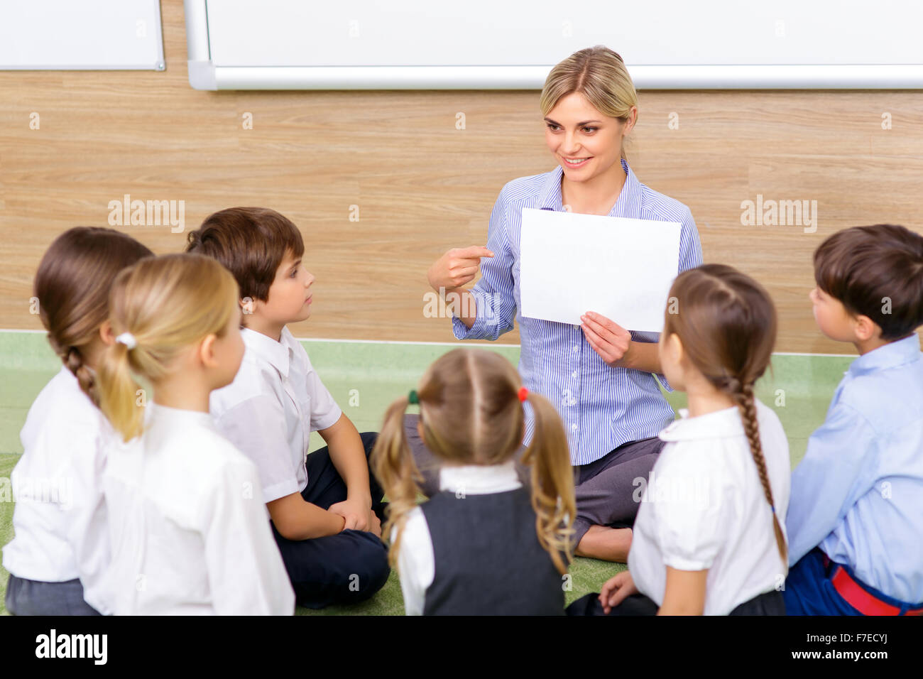 Teacher and kids are sitting in circle together Stock Photo - Alamy