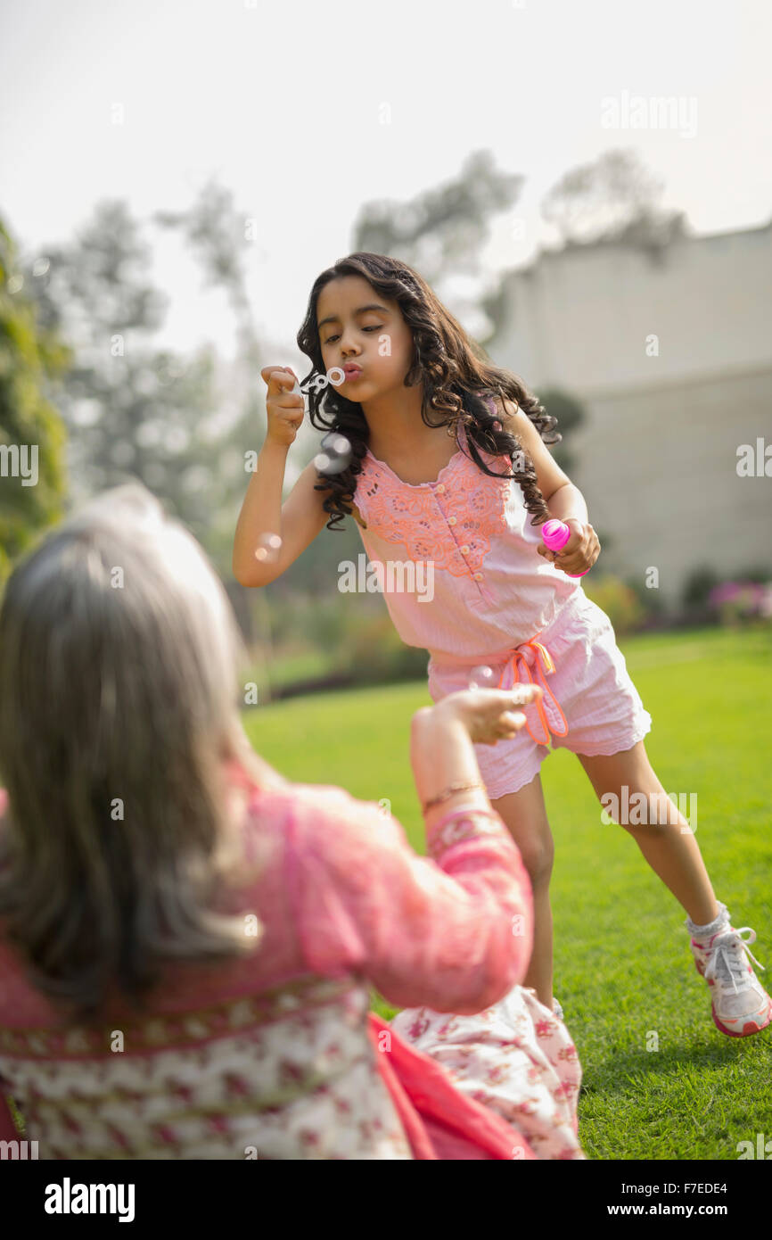 Girl (4-5) blowing bubbles with grandmother Stock Photo