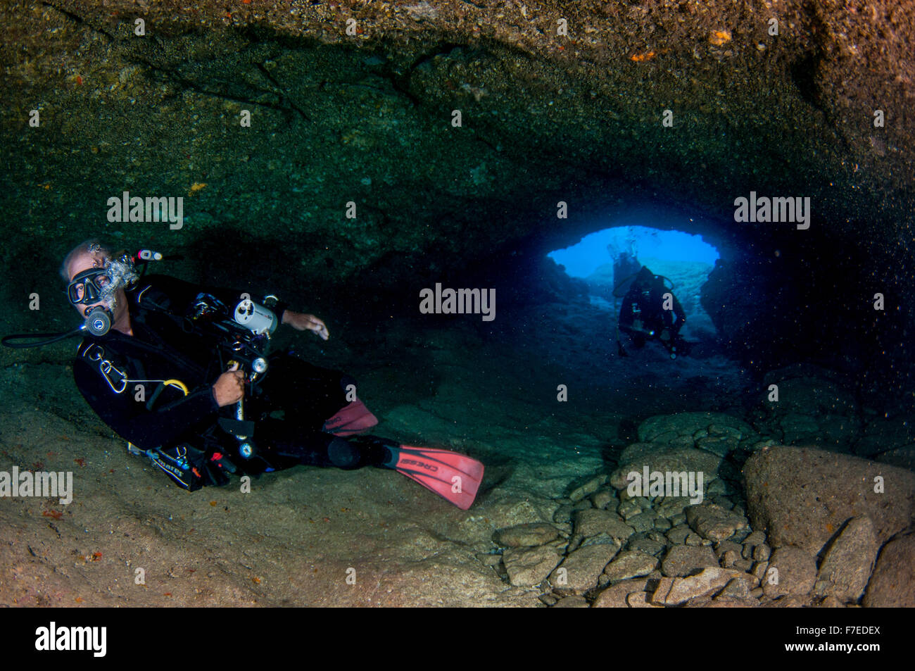 Divers explore natural caves and rocks in the Mediterranean sea off the coast of Larnaca, Cyprus, Stock Photo