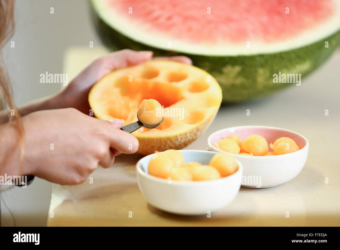 Fruit salad, scooping balls of sweet melon into a bowl. This image has a restriction for licensing in Israel Stock Photo