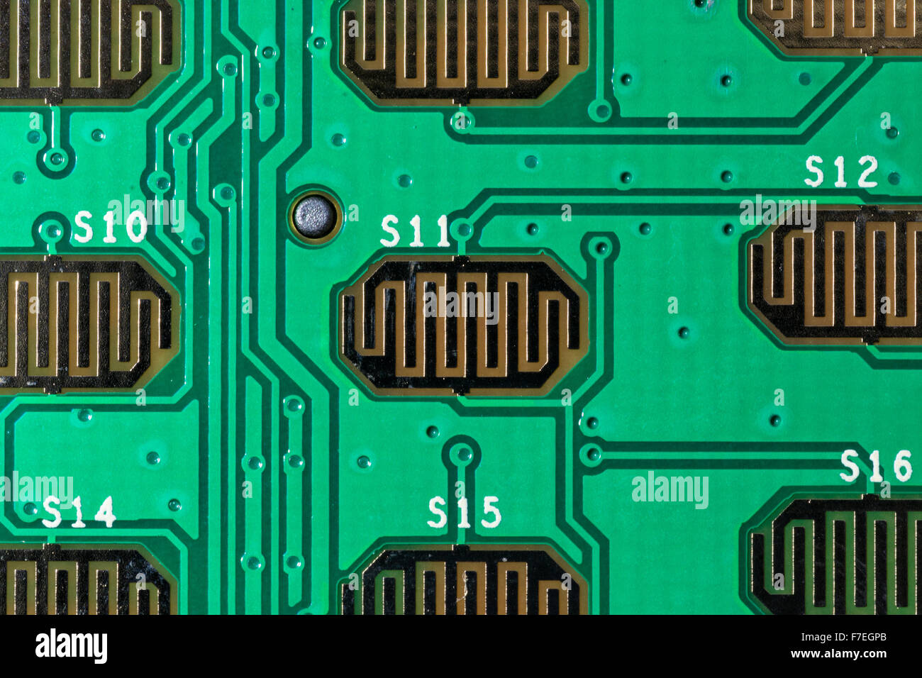 Macro close-up of the details and electronic circuitry of a green PCB board Stock Photo