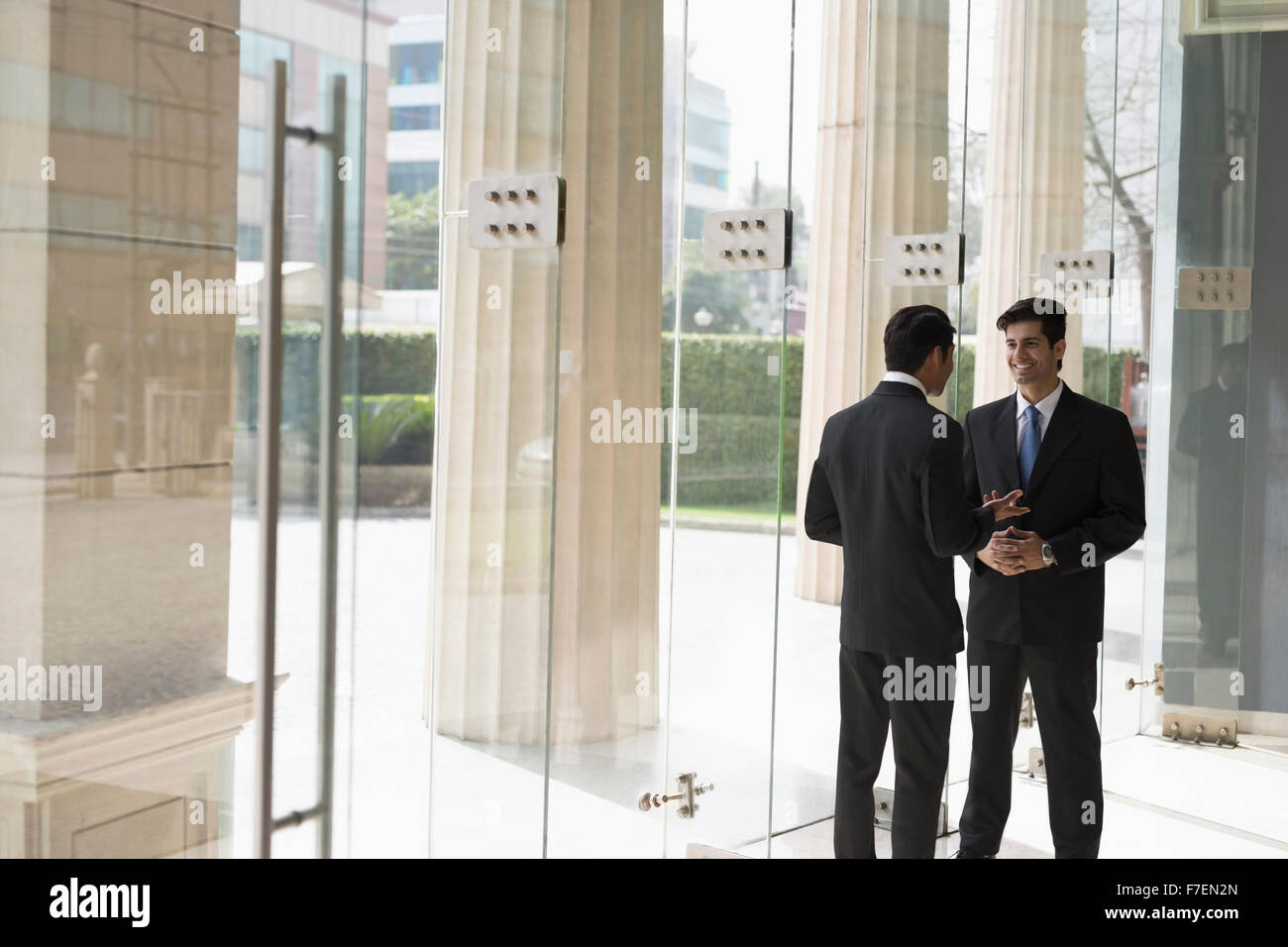 India, Businessmen talking in building lobby Stock Photo - Alamy