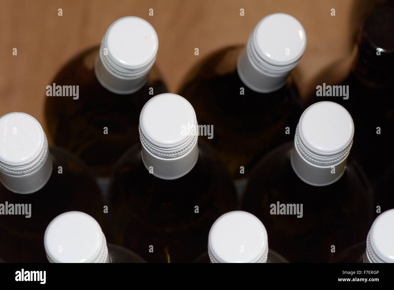 Red wine bottles stacked in a wooden bin in specialist wine shop Stock