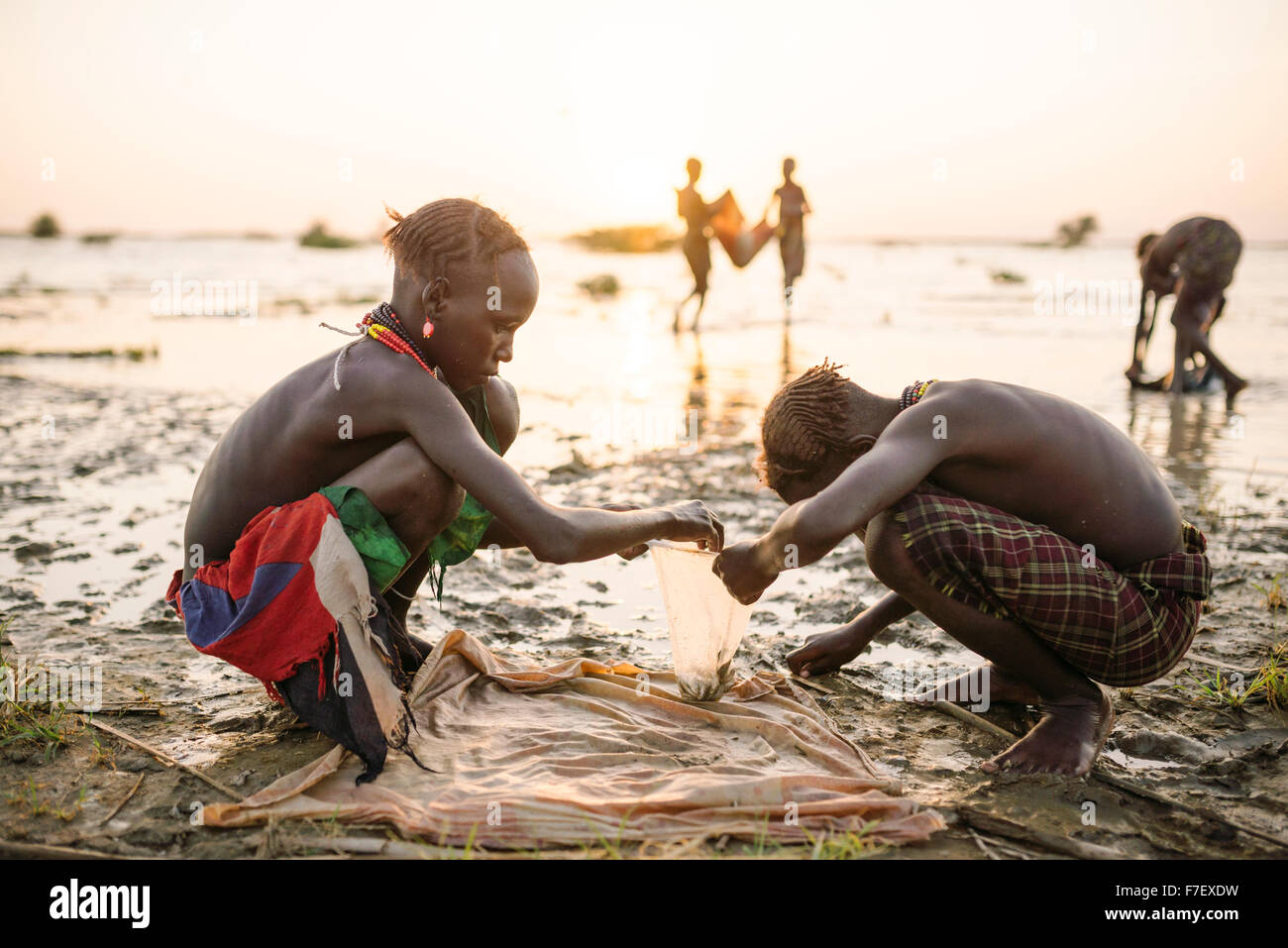 Children fishing on the shore of Turkana Lake, Dassanech Tribe, Omo Valley, Ethiopia Stock Photo