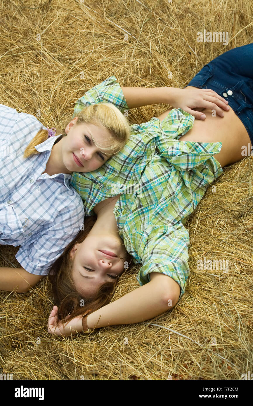 country girls restings on fresh hay bale Stock Photo - Alamy 