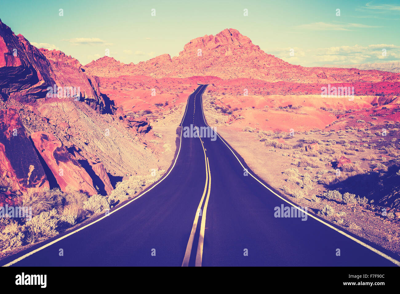 Vintage toned curved desert highway, travel concept, USA. Stock Photo