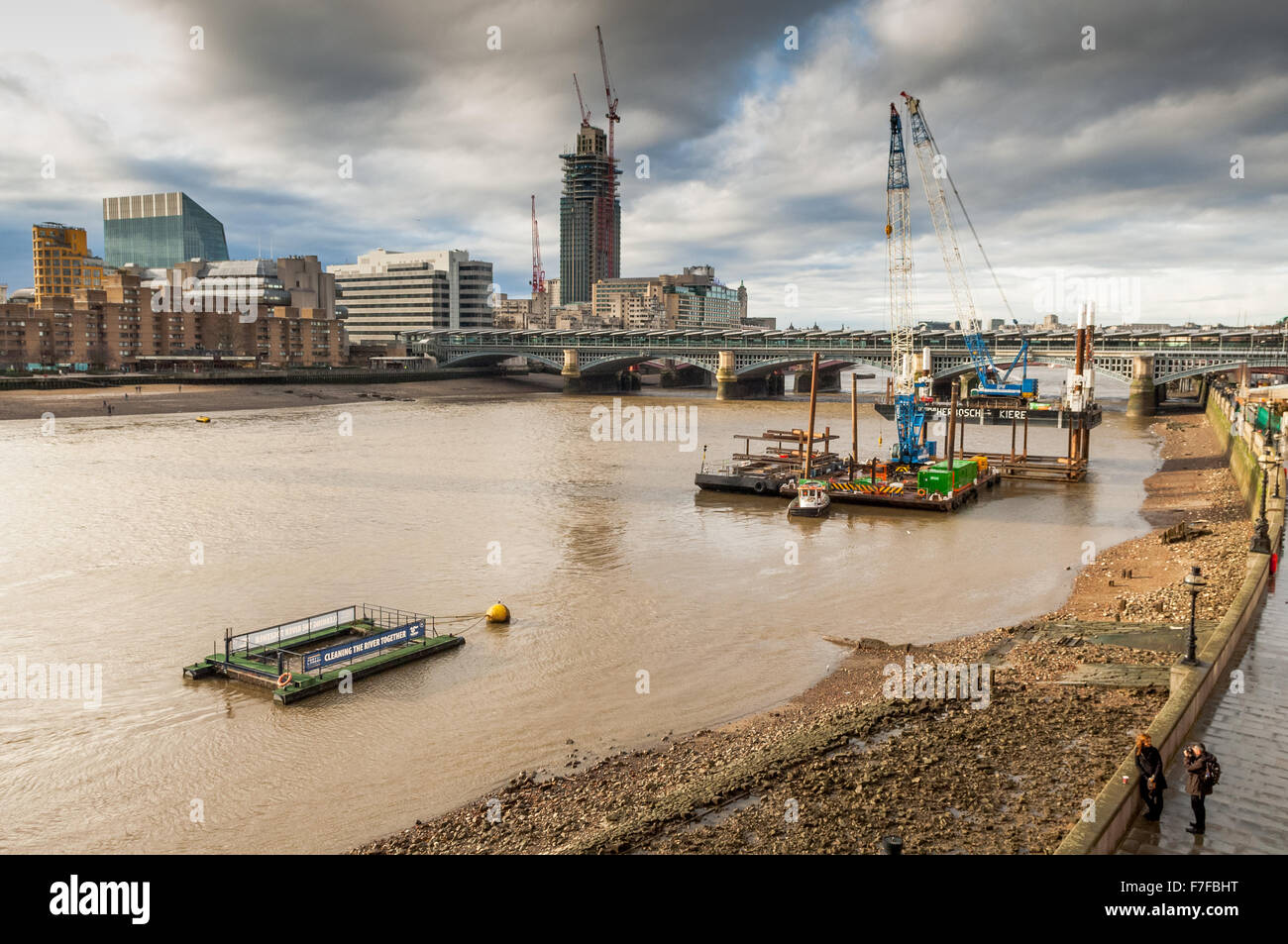 The view from The Millennium Bridge London looking over The River Thames towards the shore line at low tide. Stock Photo