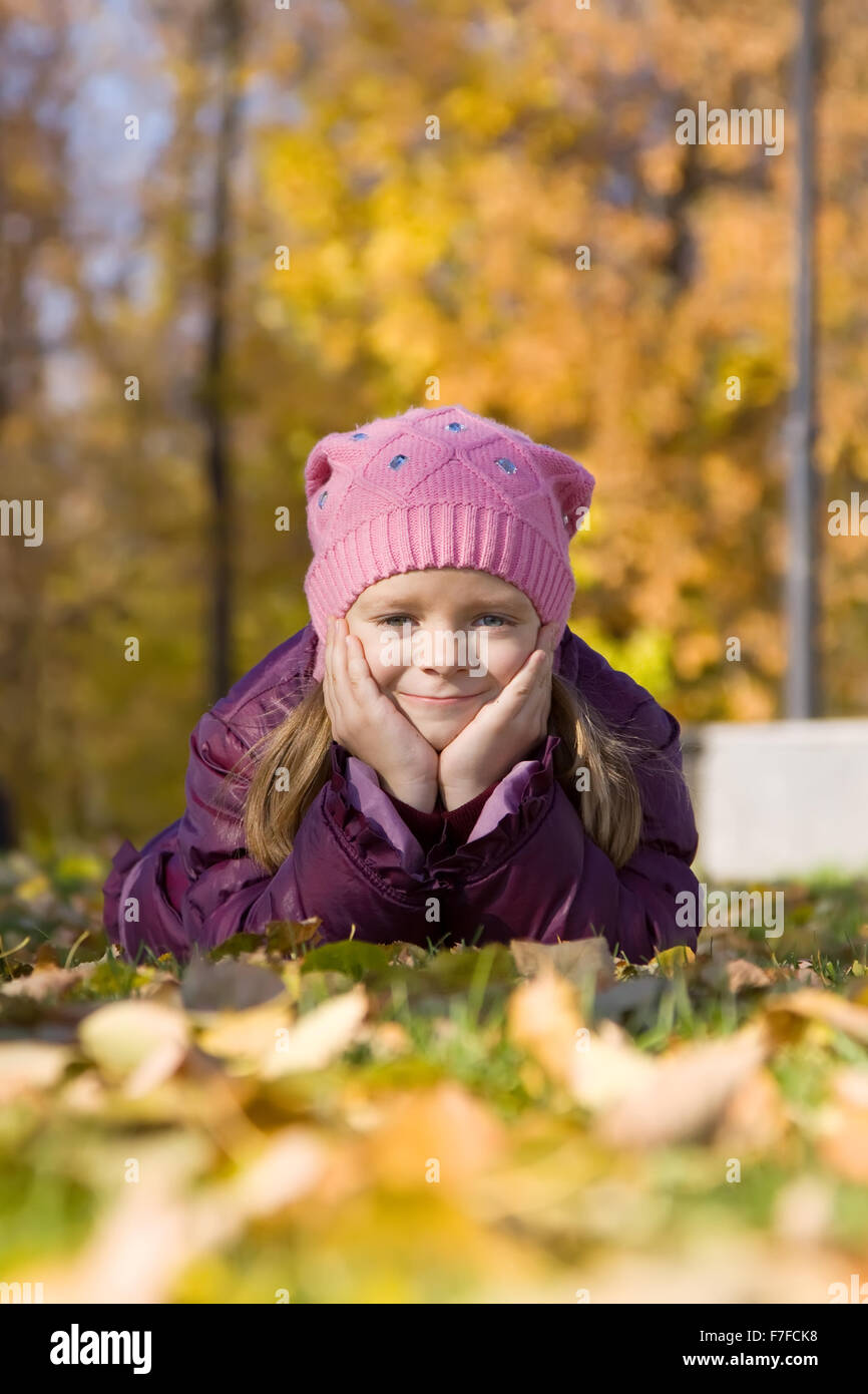 Little girl on leaves in autumn park Stock Photo - Alamy