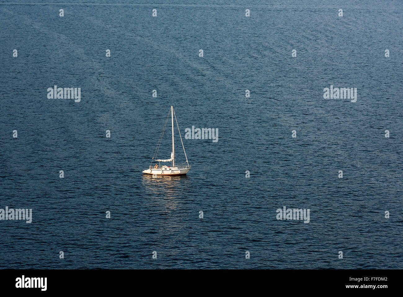 Sailboat on calm ocean water. Stock Photo