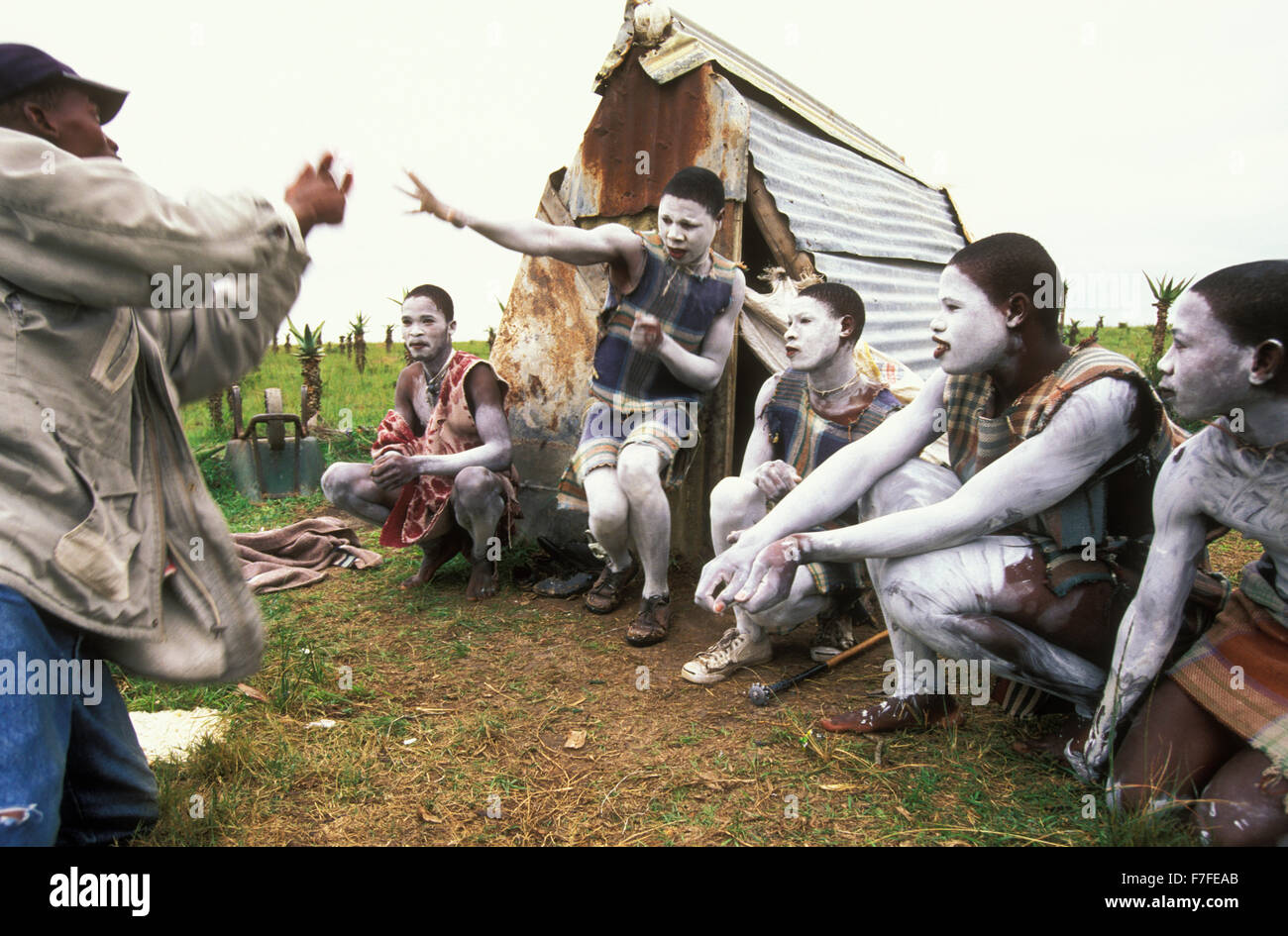 Young Xhosa initiates, who spend about a month together in a special initiation camp, play traditional games with their guardian Stock Photo