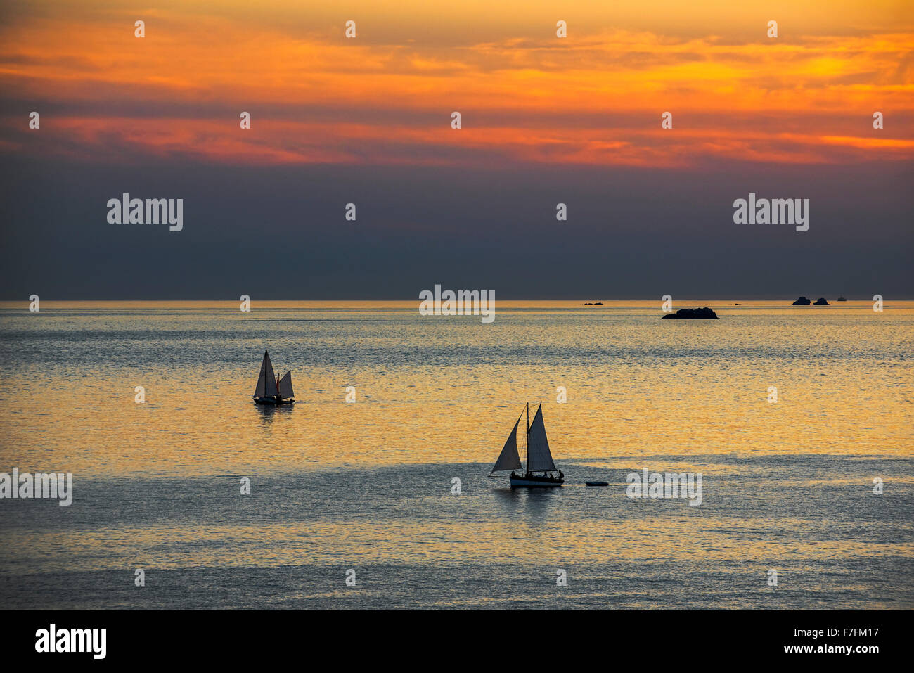 Two sailing boats at sea during sunset Stock Photo