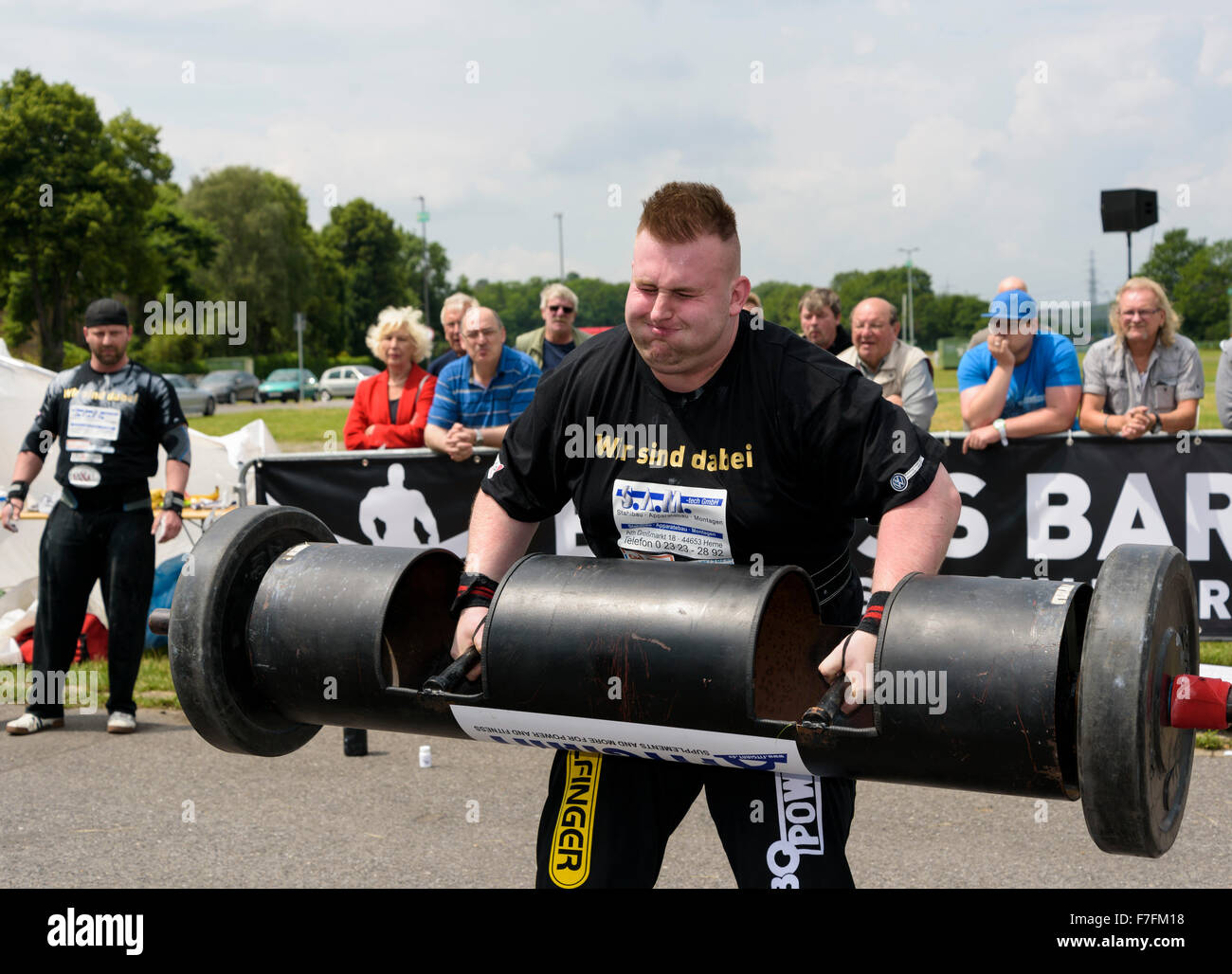 A strong man proves his strength at a public athletics sports event. Stock Photo