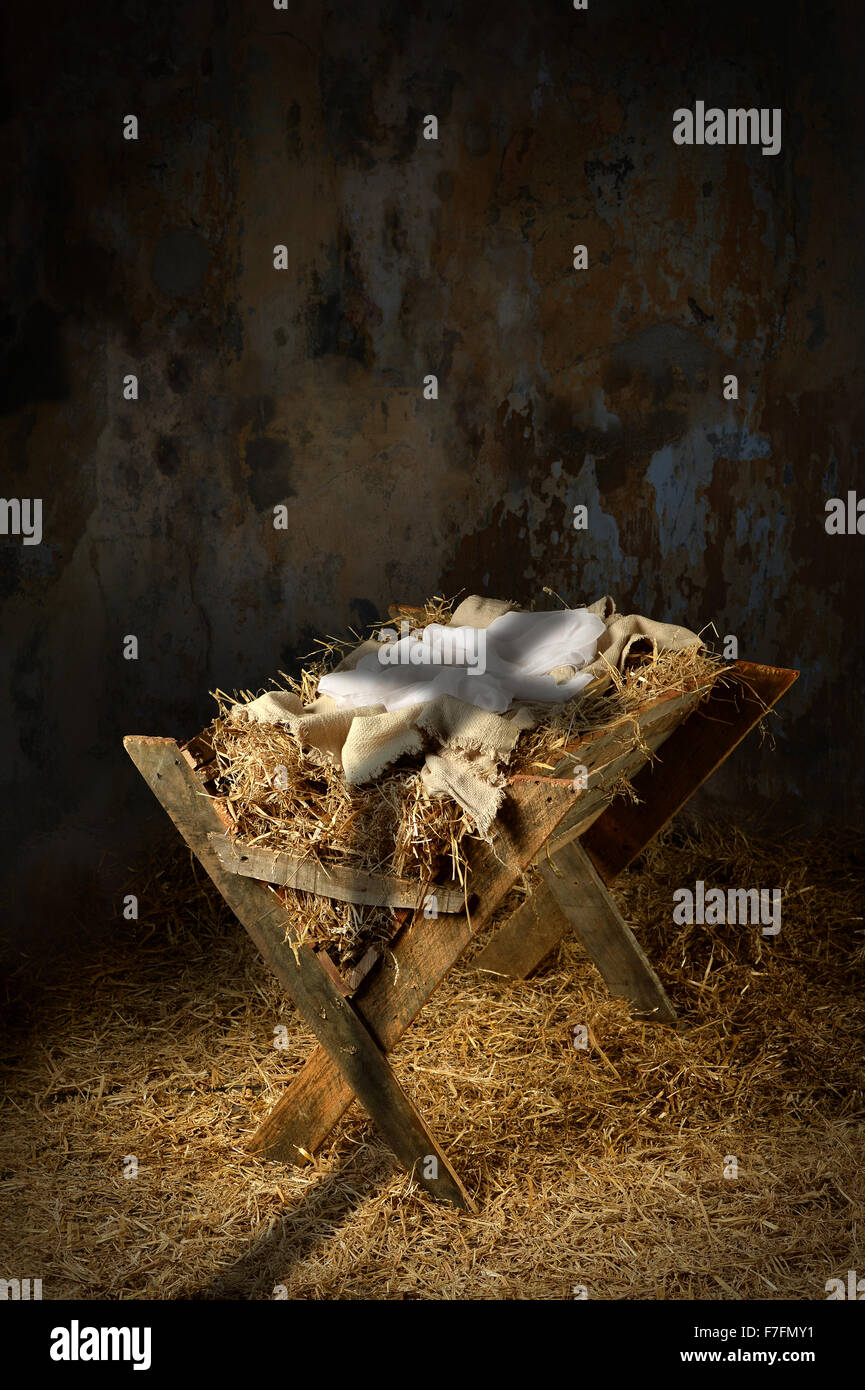 Empty manger with shadow of cross in old dirty barn Stock Photo