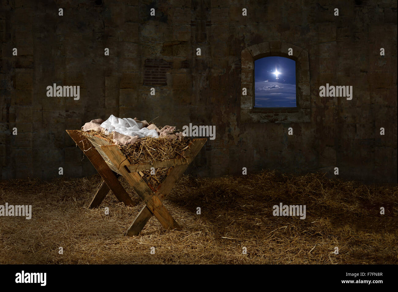 Manger in barn with window showing Christmas star Stock Photo