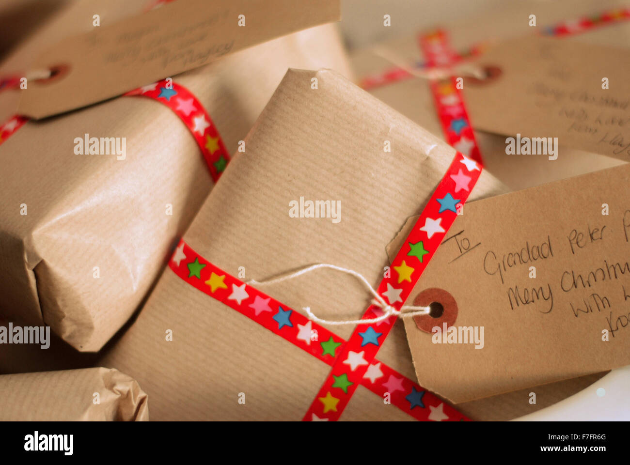 Christmas presents wrapped in brown paper with festive ribbon and luggage labels Stock Image