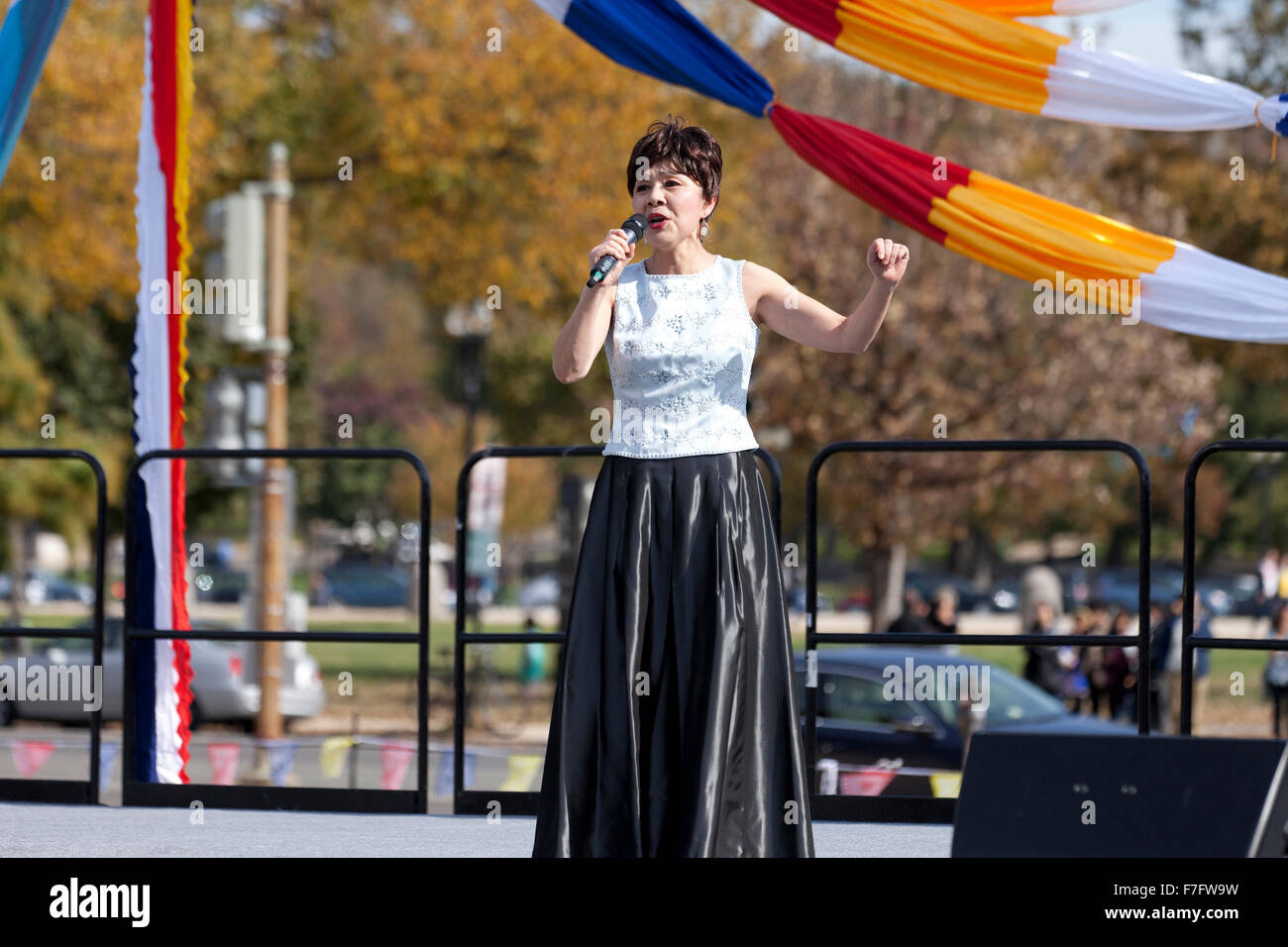 Chinese woman singing on outdoor stage at cultural festival - USA Stock Photo