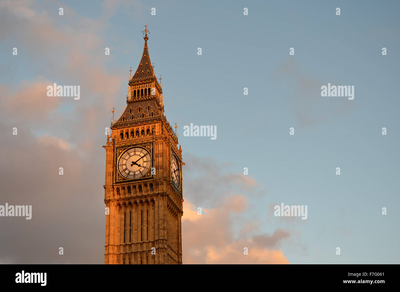 The top of the Big Ben clock tower in the late afternoon sunlight of sunset with a blue sky and some clouds in London, UK. Stock Photo