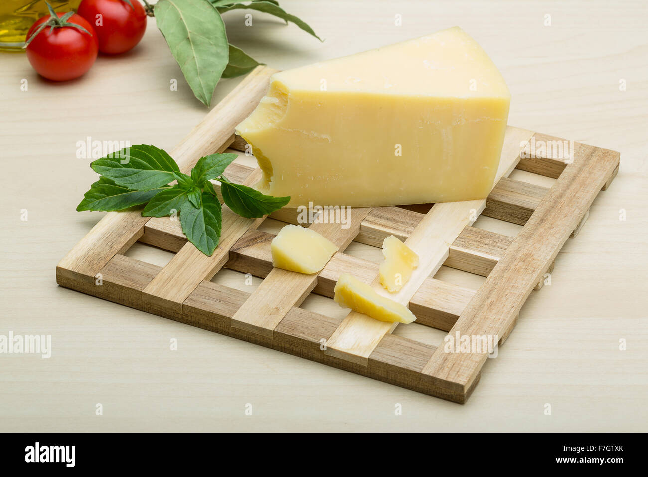 Parmesan cheese with basil leaves on the wood background Stock Photo