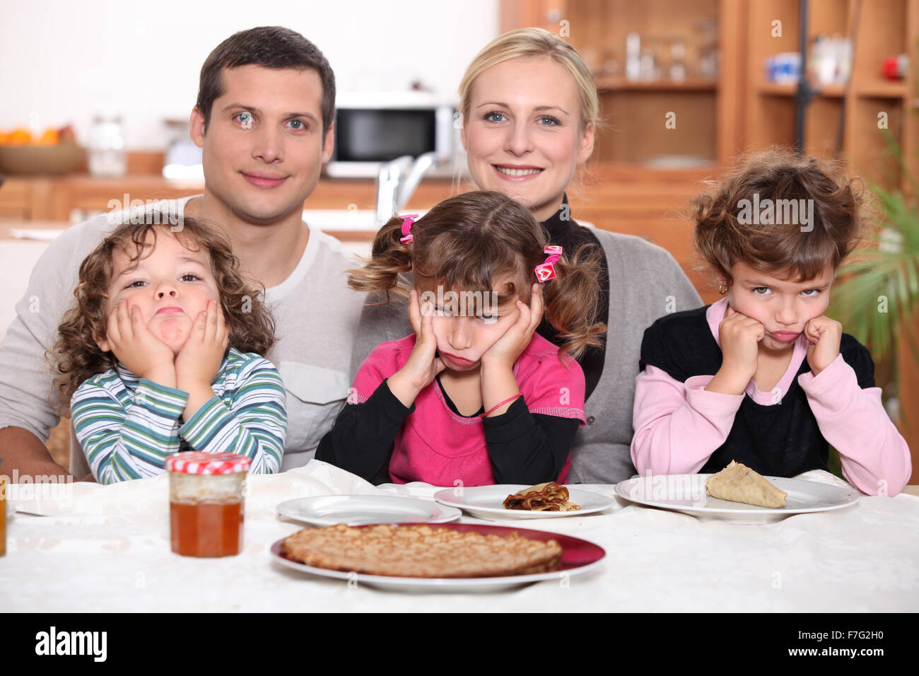 Sulky children with pancakes Stock Photo