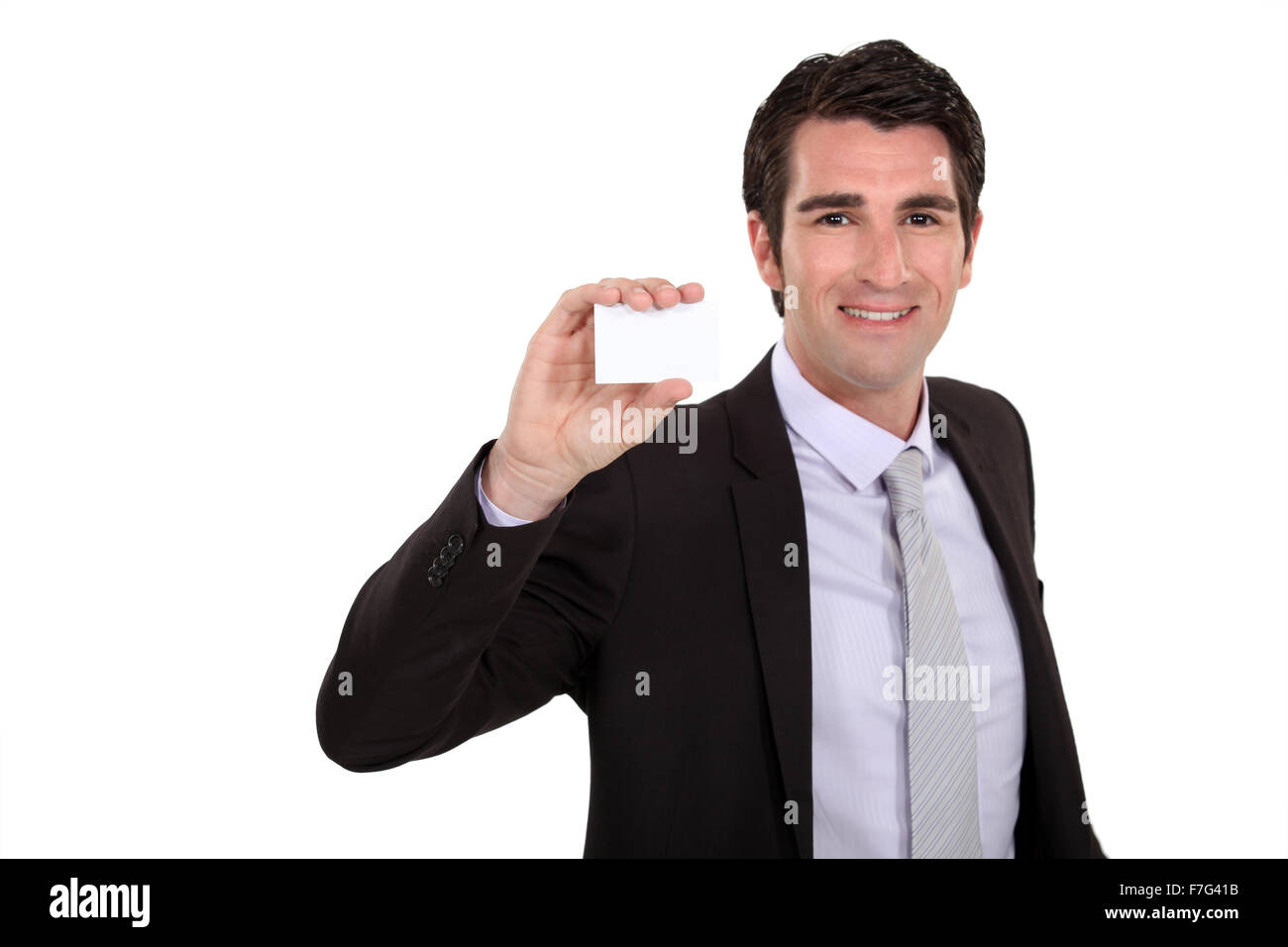 Businessman holding up hiscard Stock Photo