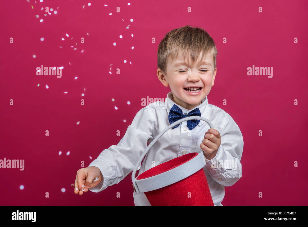 Cheerful boy throwing confetti in the air Stock Photo