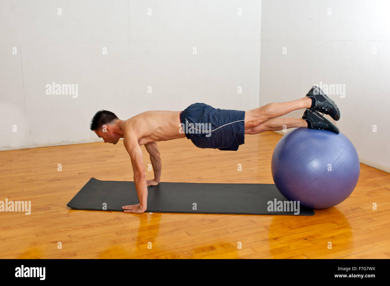 Multiracial man exercising on stability ball Stock Photo