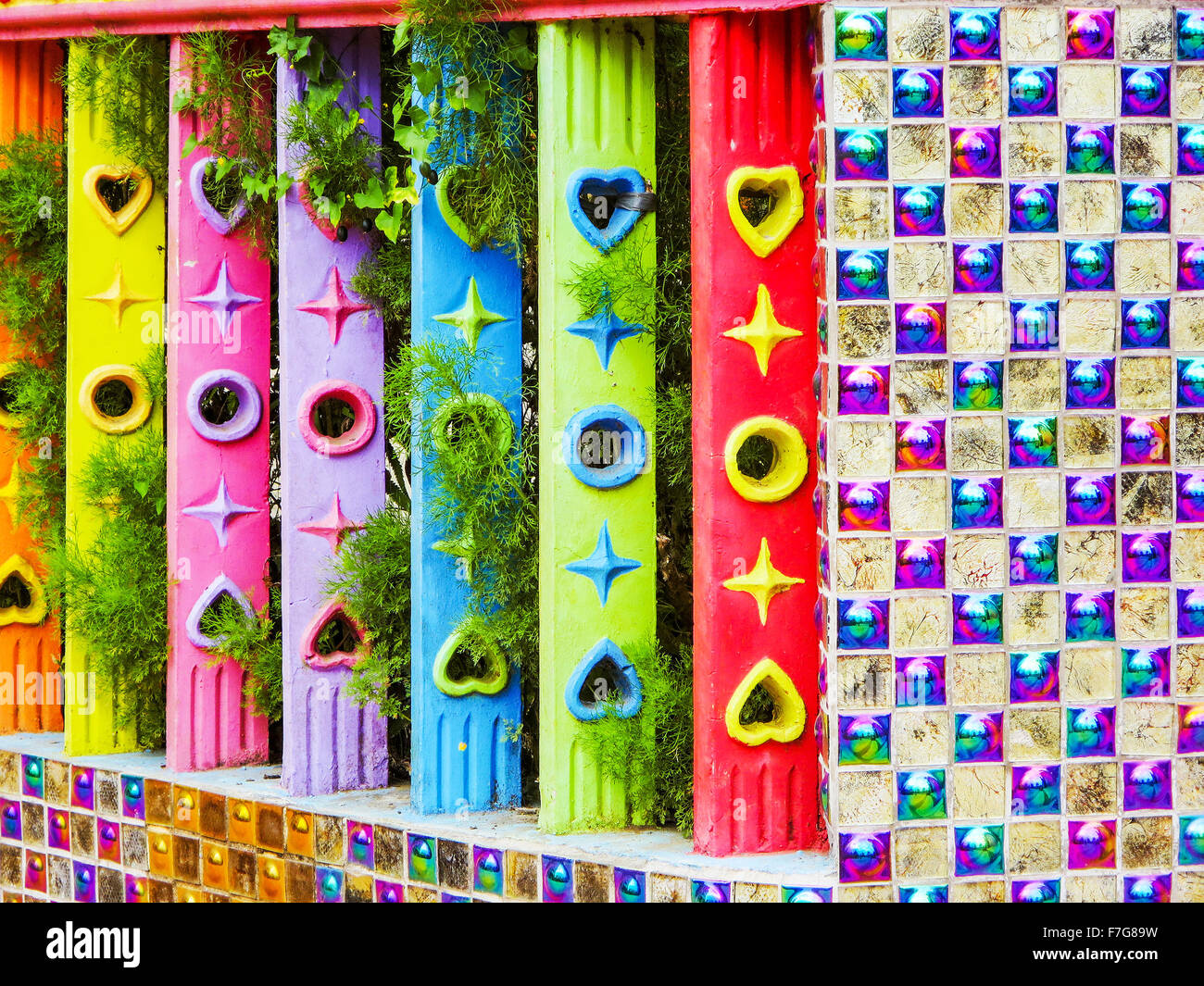 A colorful concrete whimsy garden fence of abstract design and multiple colors and shapes. Stock Photo