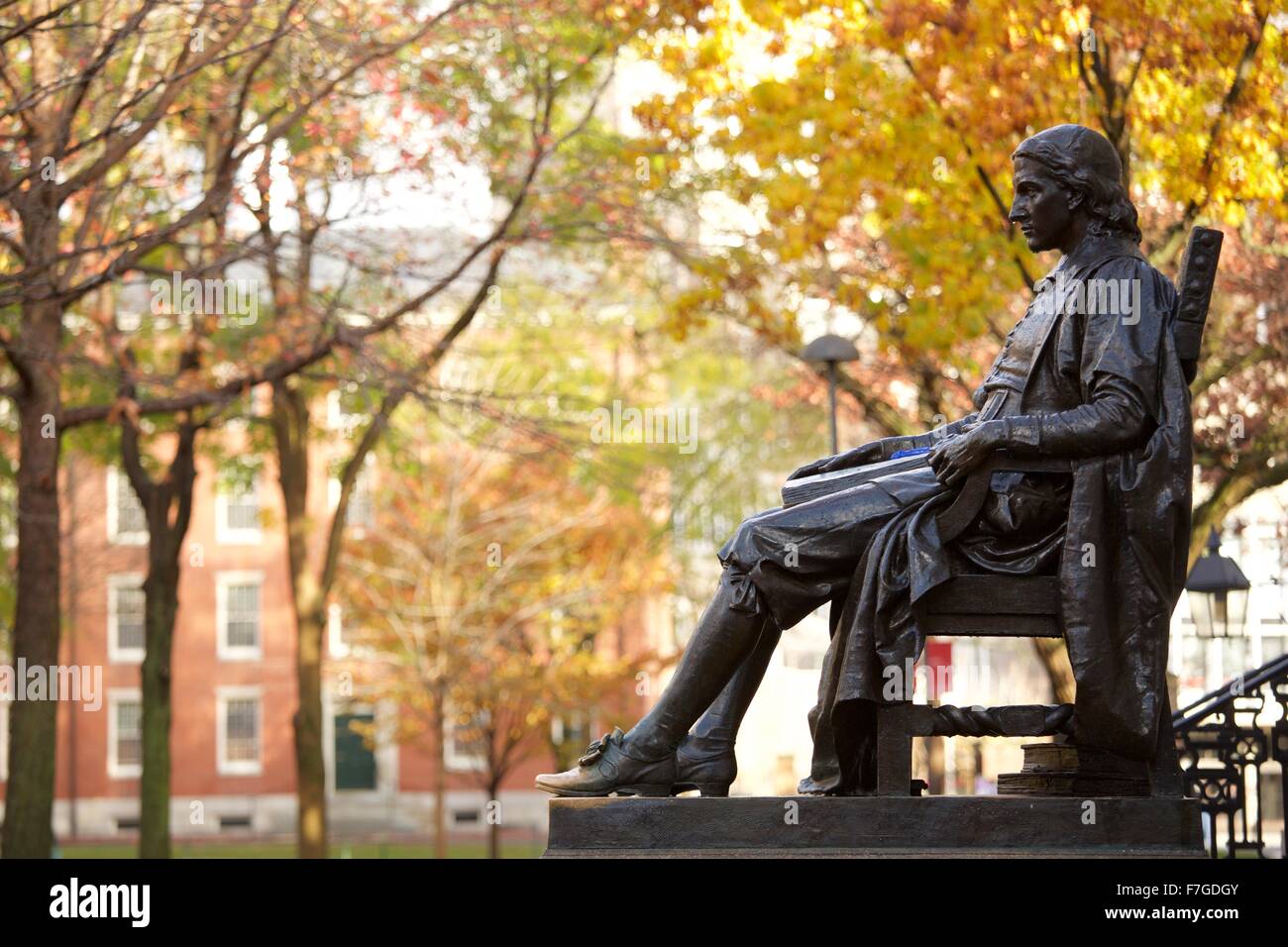 John Harvard statue in Harvard Yard in autumn, fall in Cambridge, Massachusetts. Stock Photo