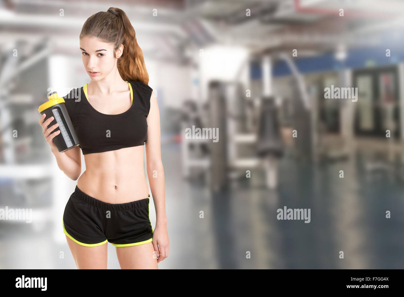 Woman about to drink a protein shake after a workout in the gym Stock Photo
