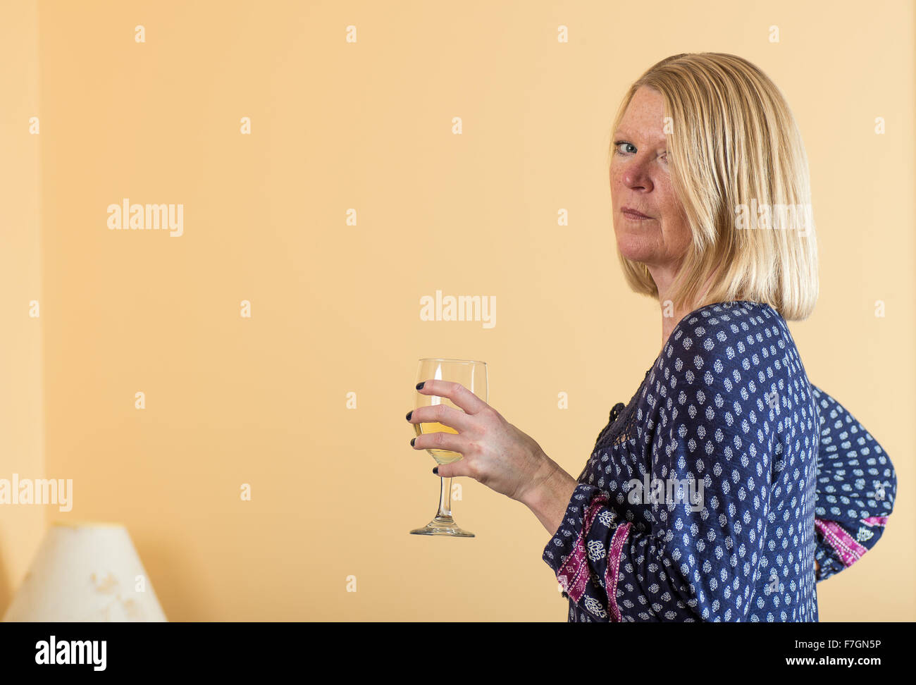 Blond woman holding a glass of white wine Stock Photo - Alamy