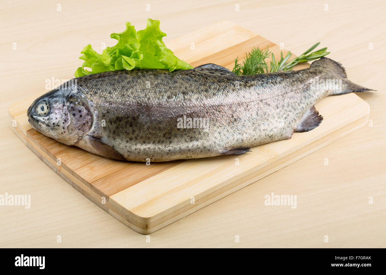 Raw fresh trout on the wood background with herbs Stock Photo - Alamy