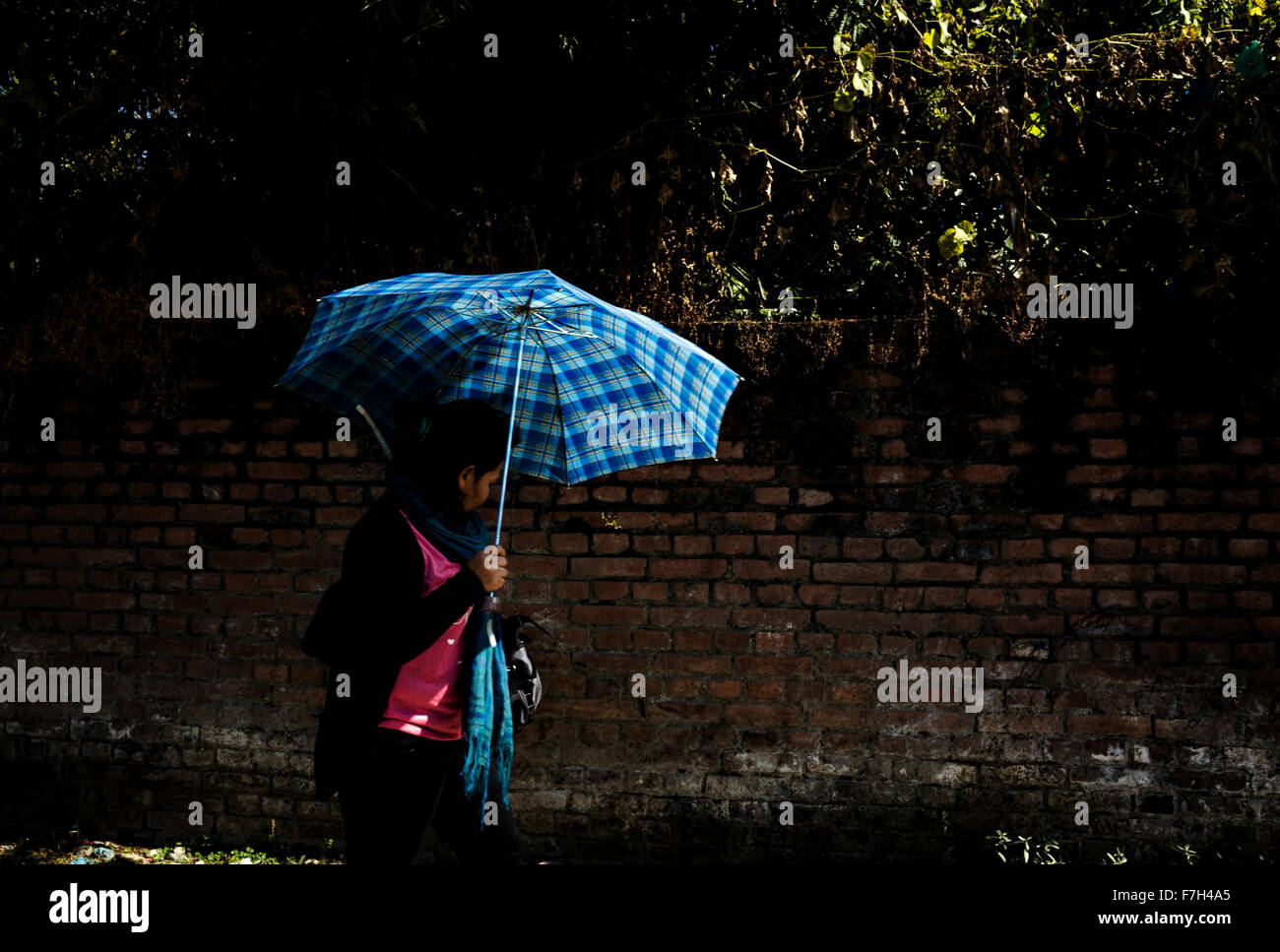 a lady with a blue umbrella for sun protection, Kathmandu, Nepal Stock Photo