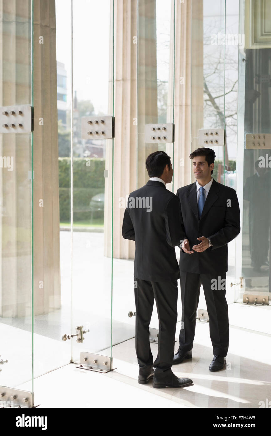 India, Two business men talking in building lobby Stock Photo - Alamy