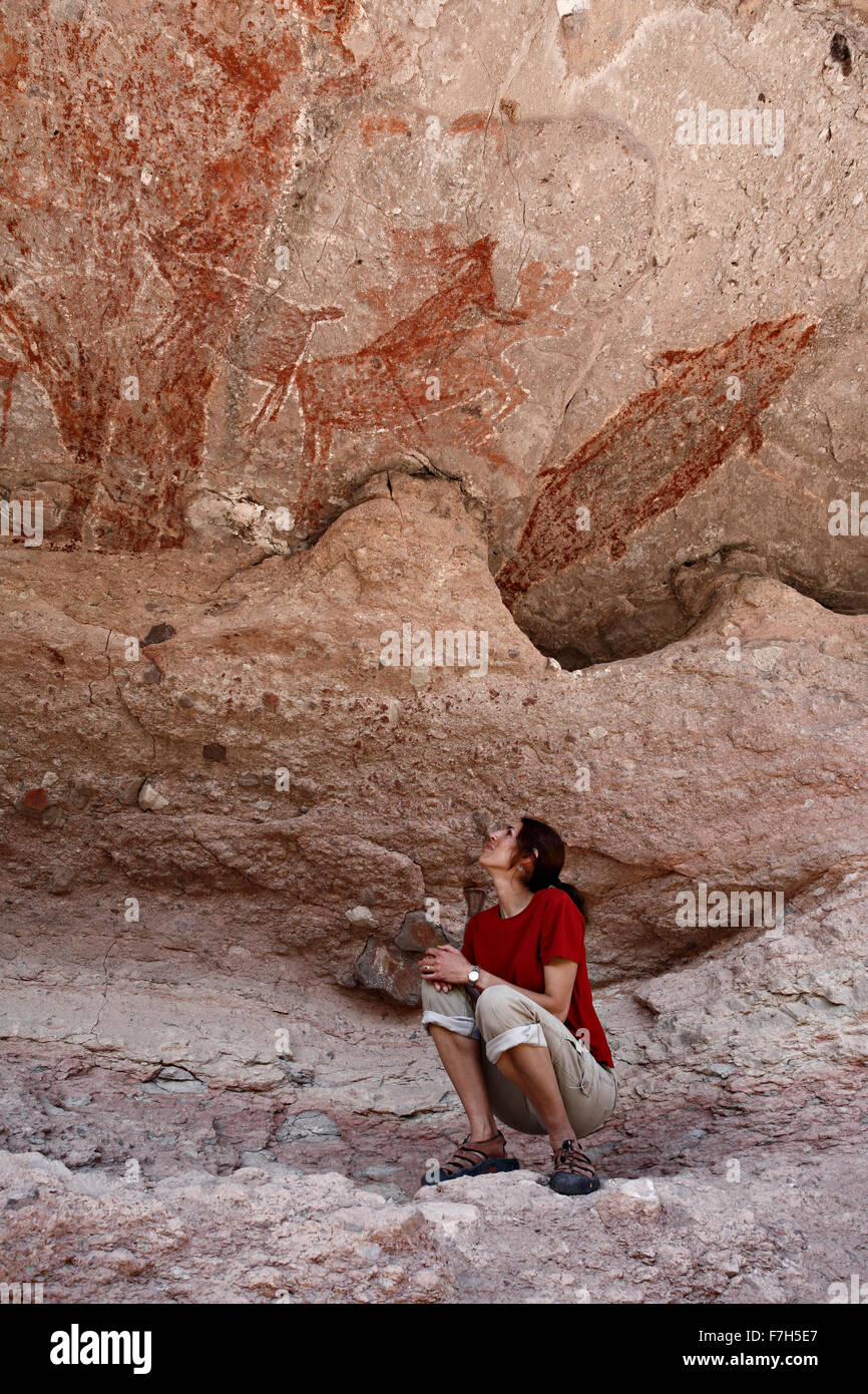 pr7181-D. woman (model released) admires petroglyphs and rock paintings of Santa Marta, which depict people, animals (deer, rabb Stock Photo