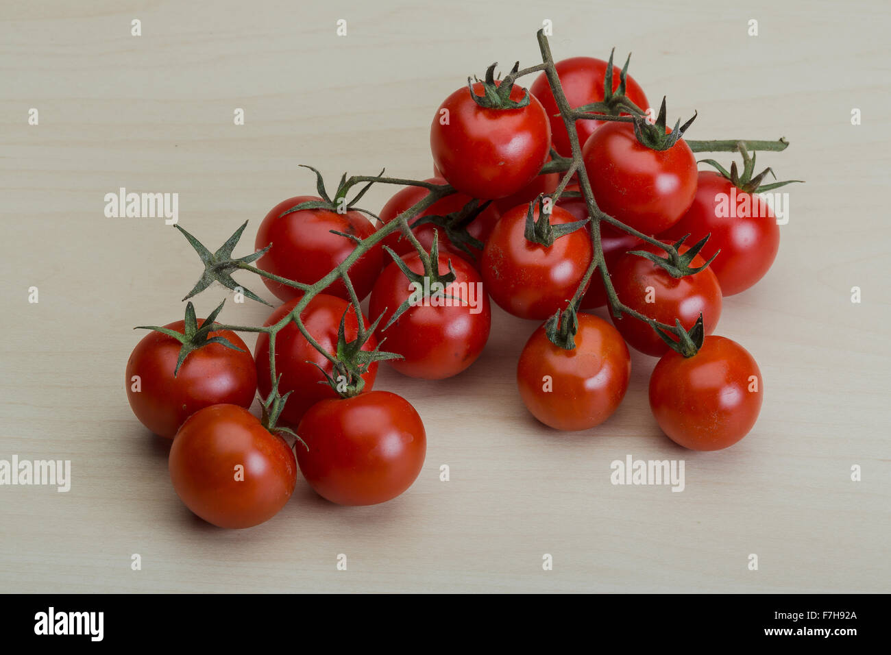 Cherry tomatoes branch on the wood background Stock Photo - Alamy