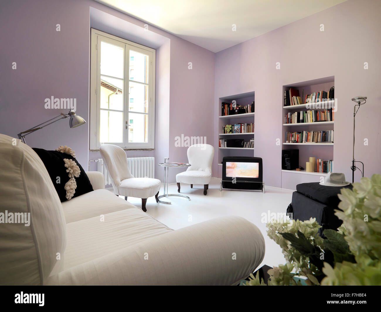classic living room with walls of lilac color and bookcase Stock Photo