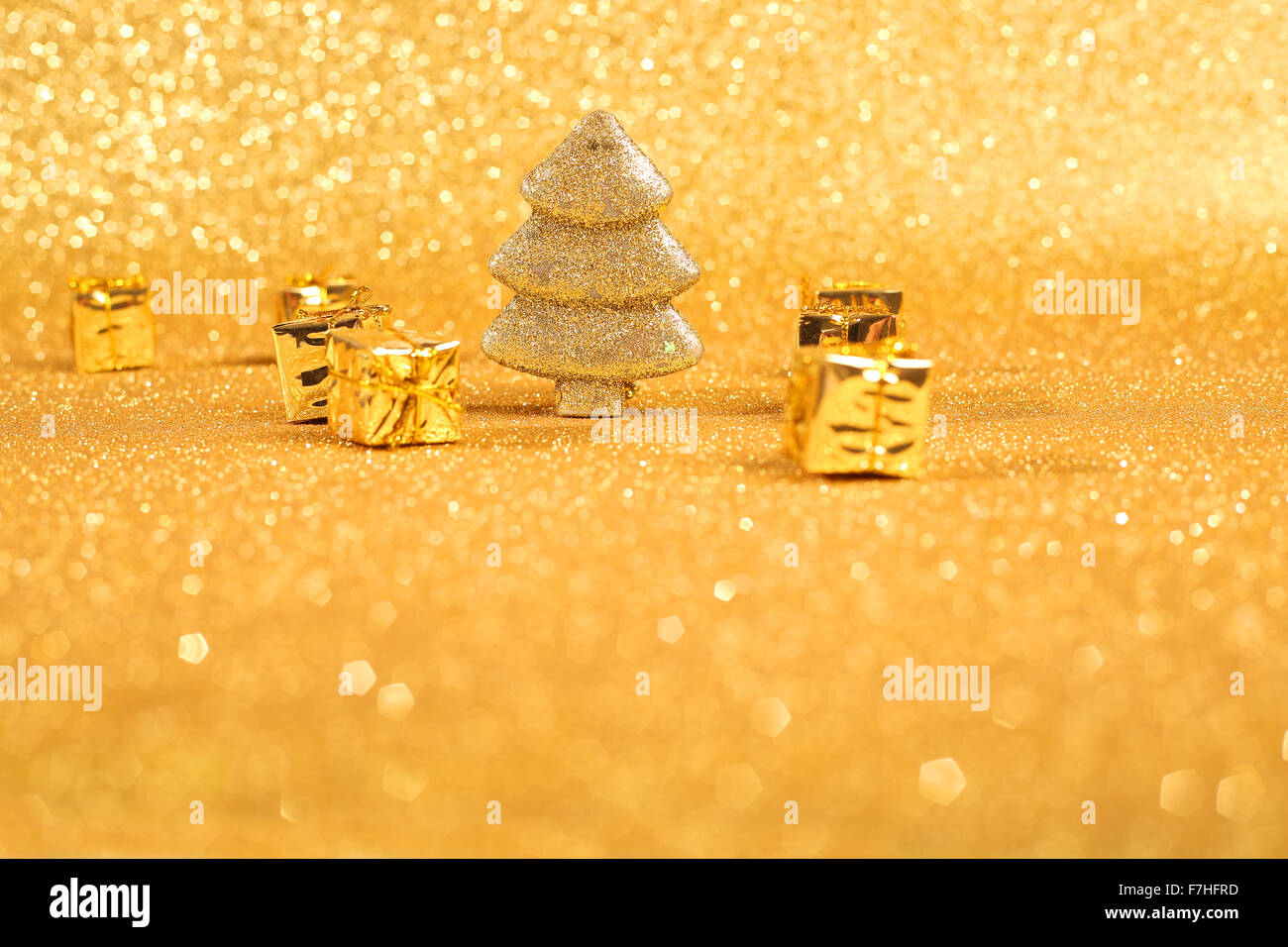 Golden christmas fir tree and gifts decoration on glitter background ...
