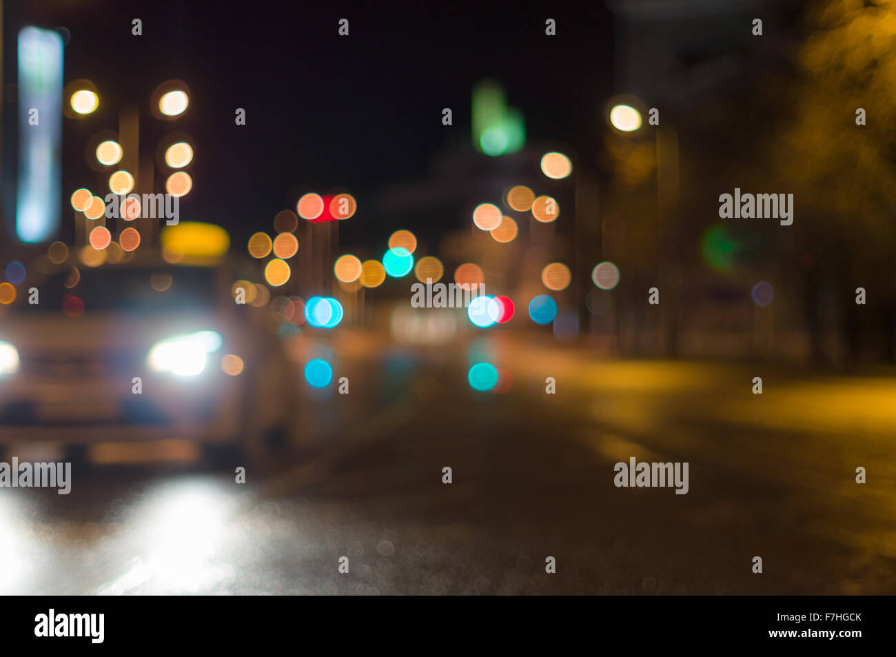 Car driving by blurred image, city road night lights on background