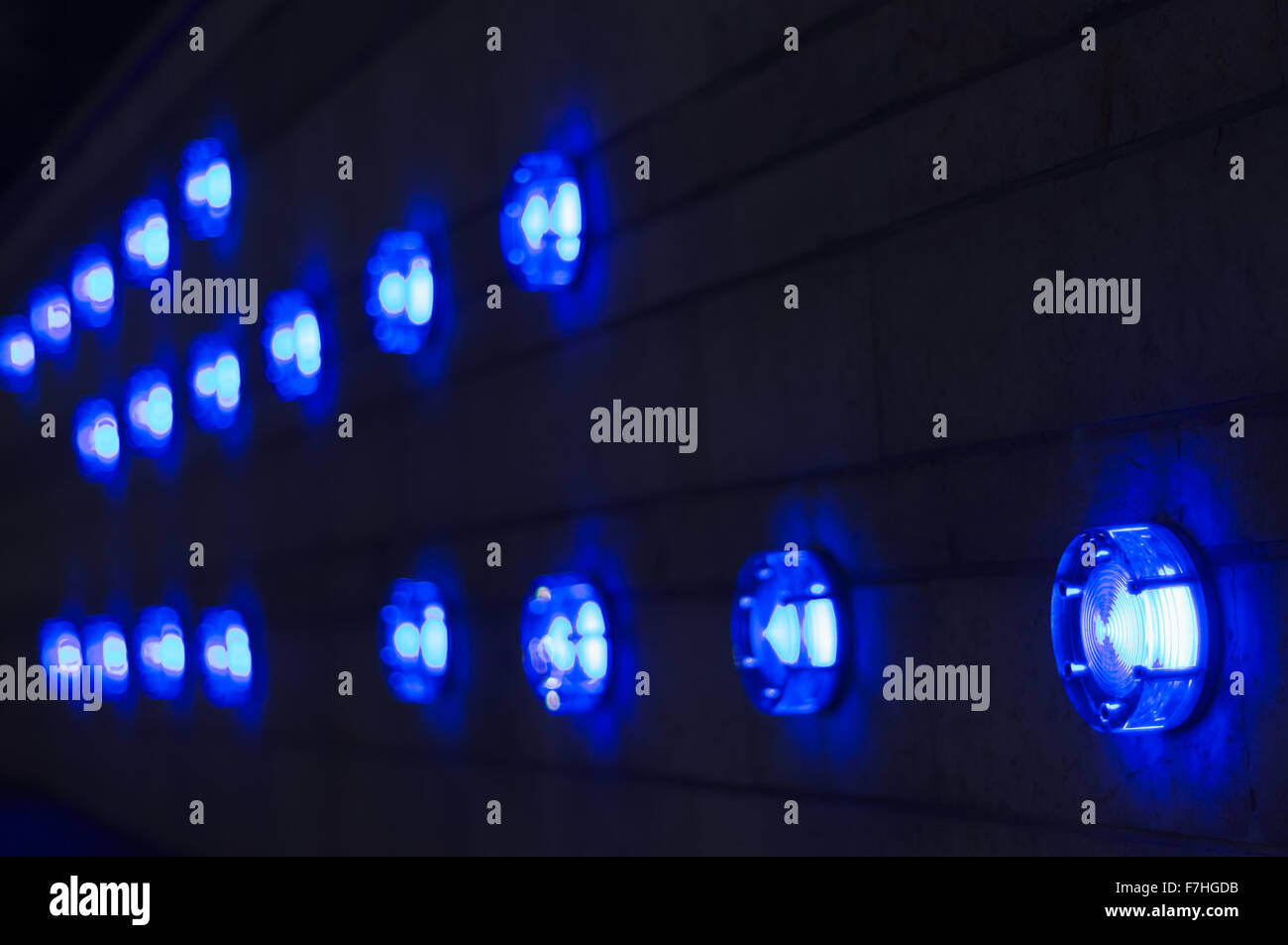 Illuminated modern blue lamps in a row on wall Stock Photo - Alamy