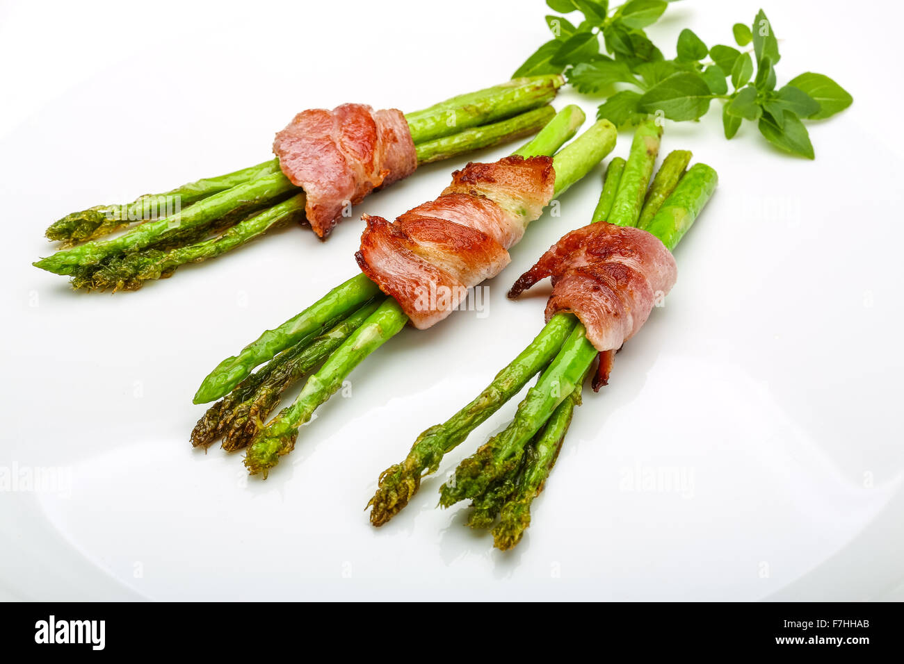 Grilled asparagus with bacon, basil and sesame Stock Photo Alamy