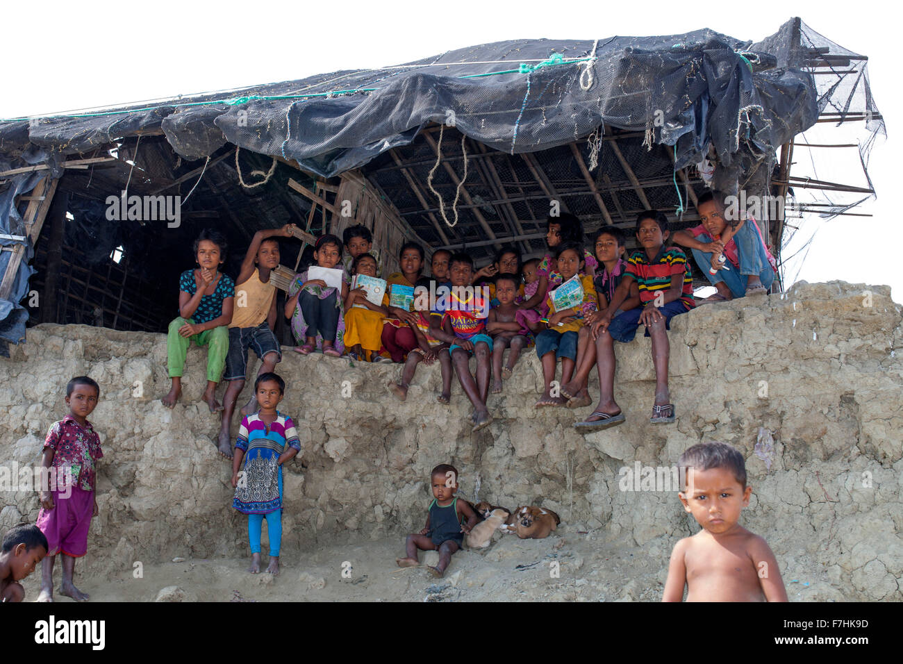 COX's BAZAR, BANGLADESH - November 29:  Children  inside a Climate Change and Sea Level Raise affected broken house  in Kutubdia Island of Cox's Bazar District on November 29, 2015.  Kutubdia, an island off the Cox's Bazar coast. the adversities of nature induced mainly by climate change. During the last two decades the impacts of climate in Bangladesh have been accellerating.Kutubdia is also hit hard. The place is very vulnerable to cyclones and storm surges, which have become more frequent and intense in Bangladesh, as well as rising sea-level and stronger waves. The result is massive erosio Stock Photo