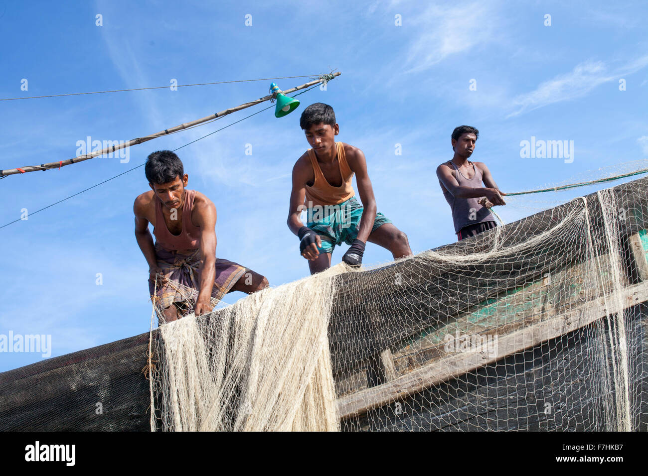 COX's BAZAR, BANGLADESH - November 29:Fisher man of Climate Change and Sea Level Raise area repairing their net to fishing in the sea near Kutubdia Islandof Cox's Bazar Dstrict on November 29, 2015.  Kutubdia, an island off the Cox's Bazar coast. the adversities of nature induced mainly by climate change. During the last two decades the impacts of climate in Bangladesh have been accellerating.Kutubdia is also hit hard. The place is very vulnerable to cyclones and storm surges, which have become more frequent and intense in Bangladesh, as well as rising sea-level and stronger waves. The result  Stock Photo