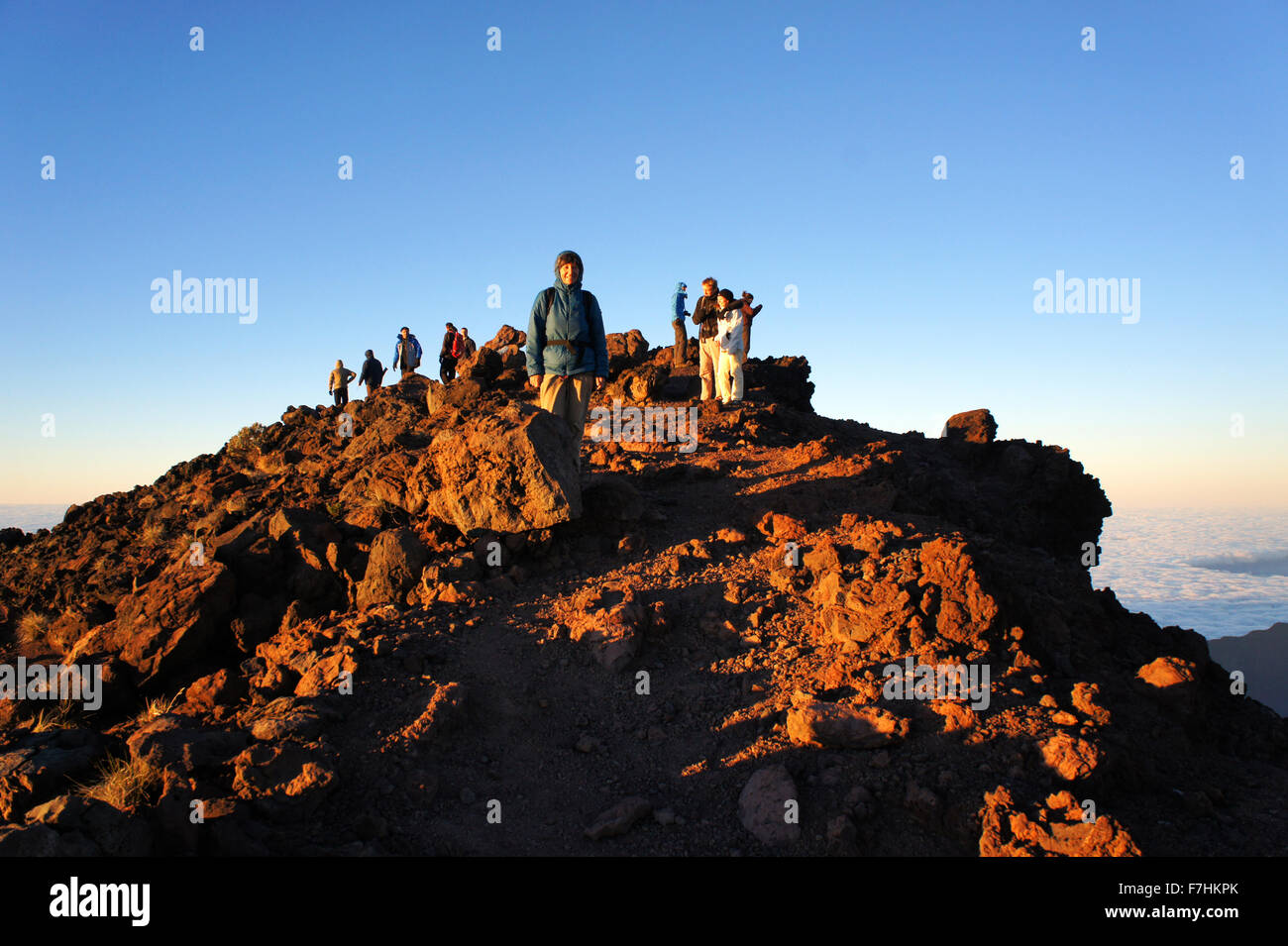 Climbers at sunrise on summit of Piton des Neiges, (3070,5 meters) highest mtn. on island La Réunion, Francelotscher Stock Photo