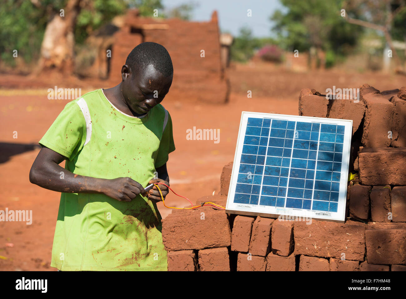 MALAWI, farmer recharges his mobile phone with solar panel in village Stock Photo