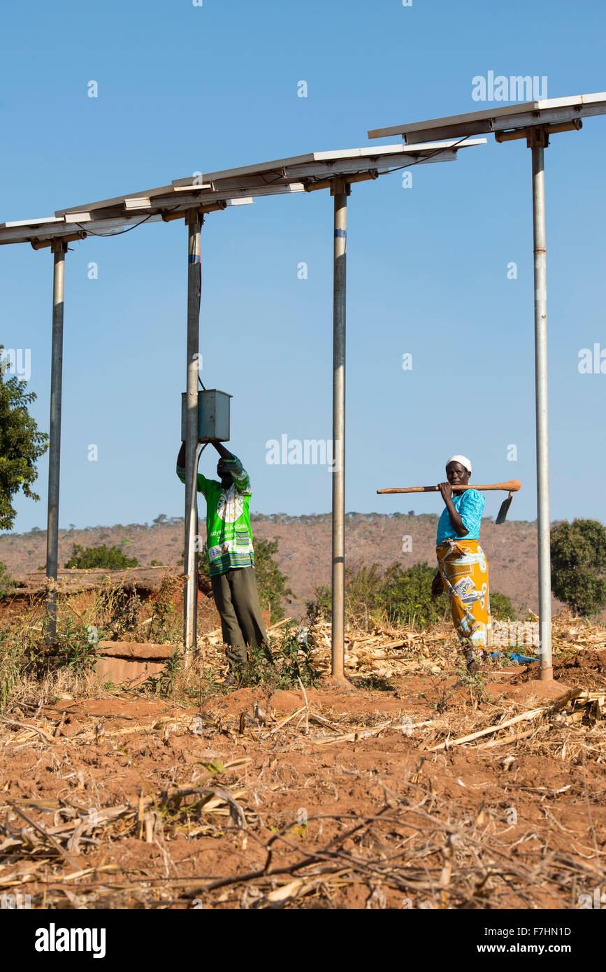 MALAWI, village Zingiziwa, solar powered water pump for irrigation and water supply in village, woman with hoe Stock Photo