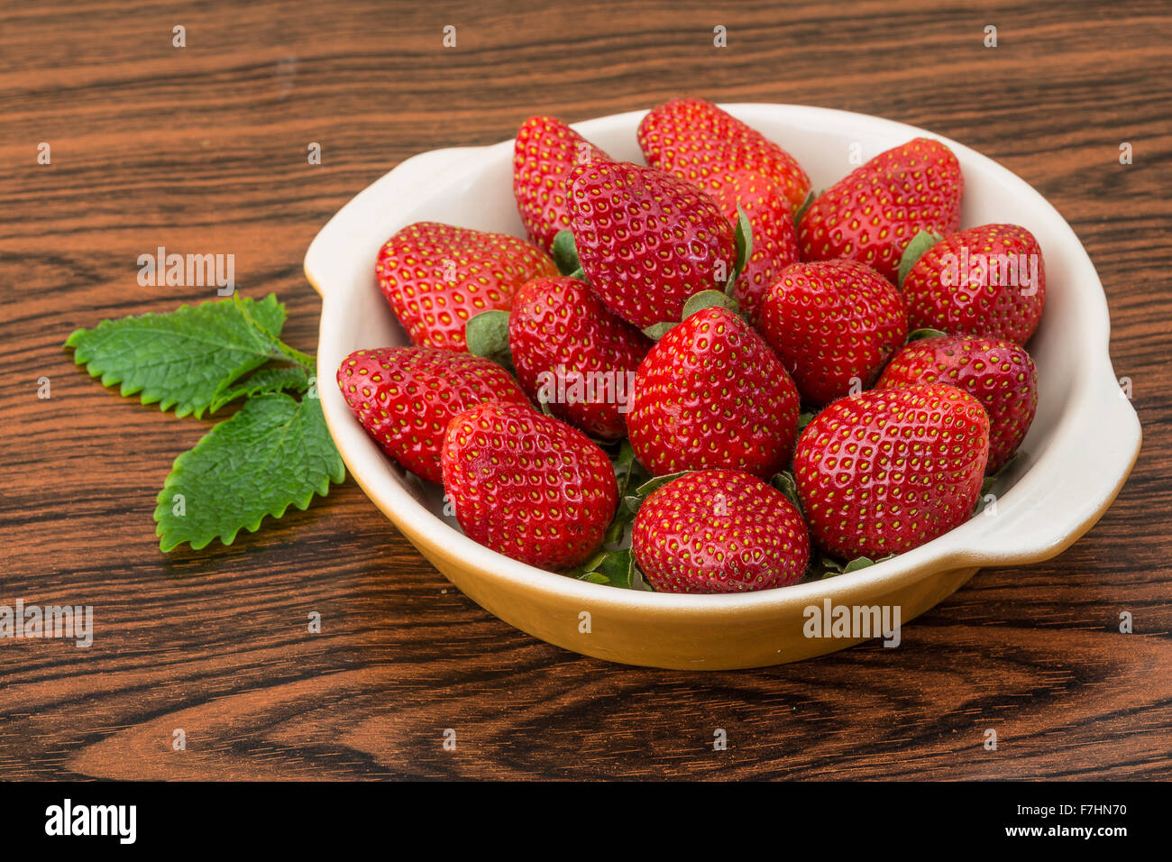 Fresh ripe strawberries in the bowl on wooden background Stock Photo ...