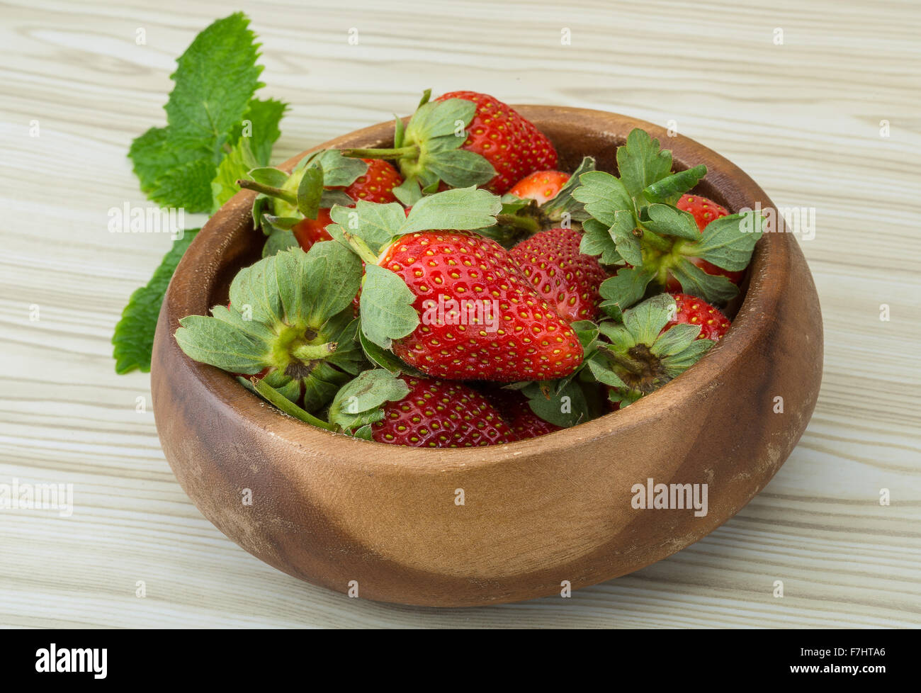 Fresh ripe strawberries in the bowl on wooden background Stock Photo ...