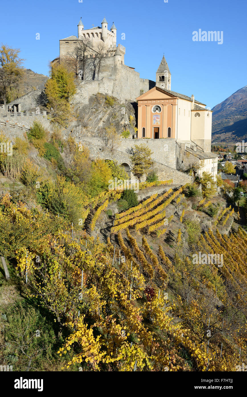 Castle and Church of Saint-Pierre above a vineyard with autumnal colors at their peak. Aosta Valley, Italy. Stock Photo