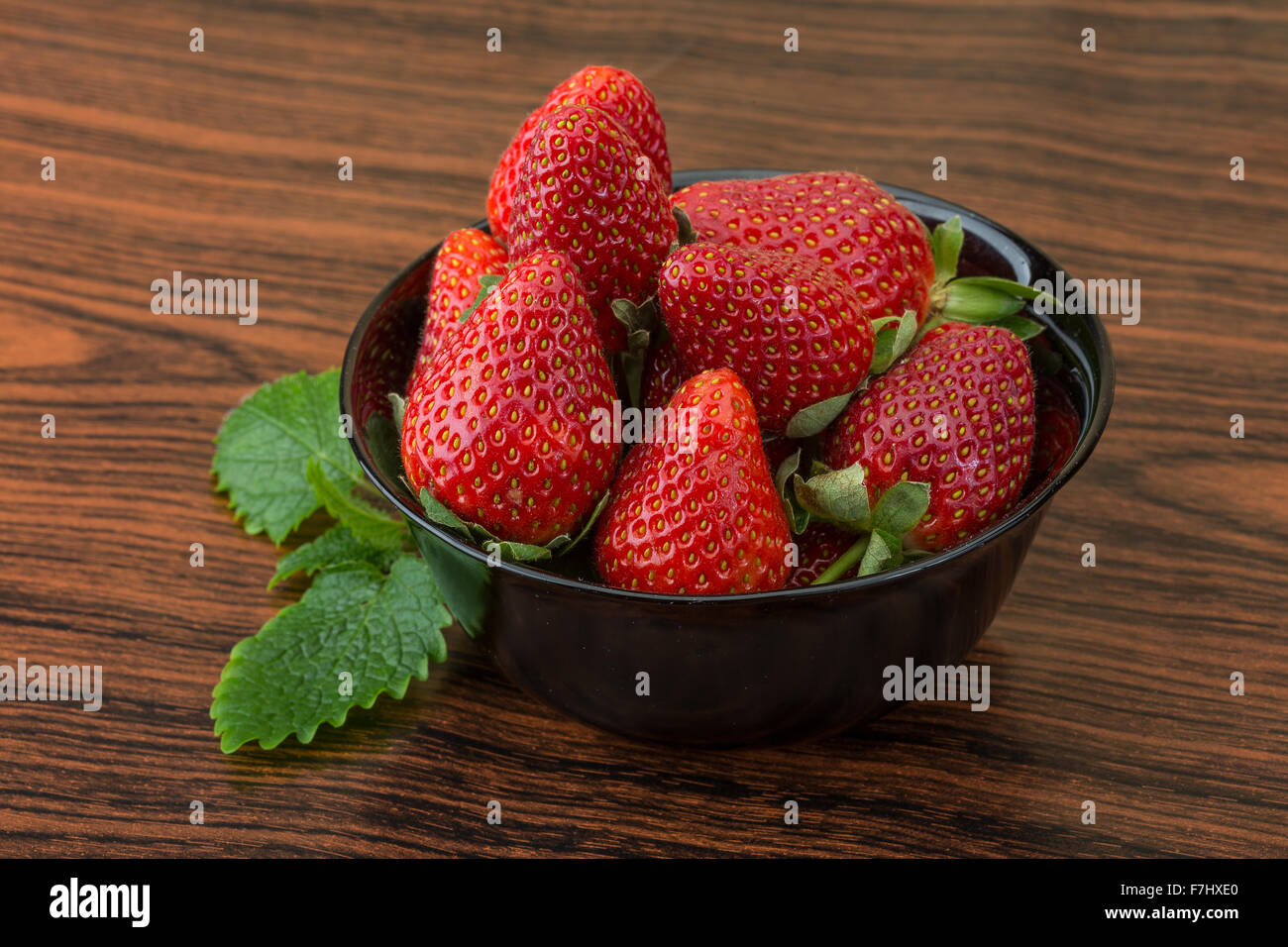 Fresh ripe strawberries in the bowl on wooden background Stock Photo ...